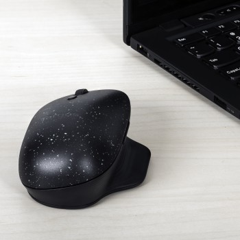 Targus ErgoFlip EcoSmart mouse, ergonomic design for both hands. A black Targus ErgoFlip EcoSmart mouse on a light-colored desk near a laptop.