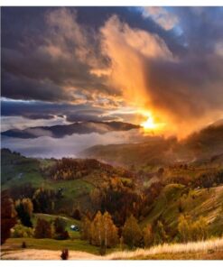 Mountain landscape in autumn colors at sunset An autumnal landscape with mountains and forest. The sunset illuminates the clouds and valley.