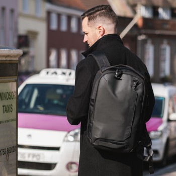 Targus Commuter EcoSmart 16'' backpack for urban use Black Targus backpack in use on a man's back in an urban setting, taxis in the background.