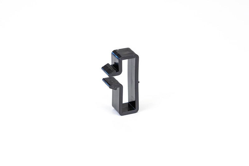 Wisol cable clip for mounting - a convenient and durable choice. Black plastic cable clip with two holders and a rectangular shape on a white background.